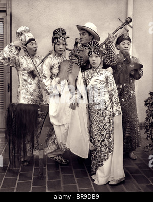 1920 AMERICAN COWBOY acteur jouant le rôle d'INSTRUMENT DANS UN GROUPE DE MUSICIENS CHINOIS FILM HUMOUR HOLLYWOOD CALIFORNIA USA Banque D'Images