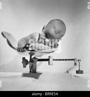 Années 1940 Années 1950 bébé couché sur l'échelle de la pesée Banque D'Images
