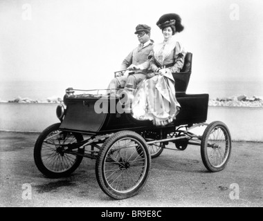 1890s 1900s COUPLE RIDING IN ANTIQUE AUTOMOBILE VOITURE SANS CHEVAUX Banque D'Images