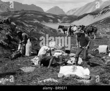 Années 1920 Années 1930 TROIS HOMMES COWBOYS AU CAMPING DE PRÉPARER DES ALIMENTS CHEVAUX EN ARRIÈRE-PLAN L'ALBERTA CANADA Banque D'Images