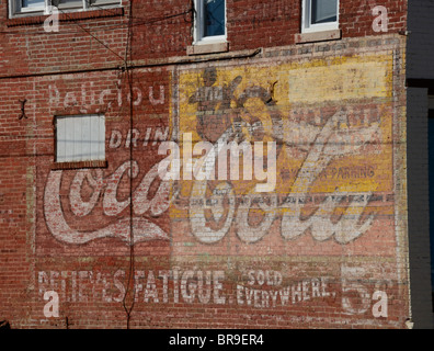 Très vieille petite annonce pour Coca-Cola et Yamaha Motos peint sur le côté d'un vieux bâtiment en brique. Banque D'Images