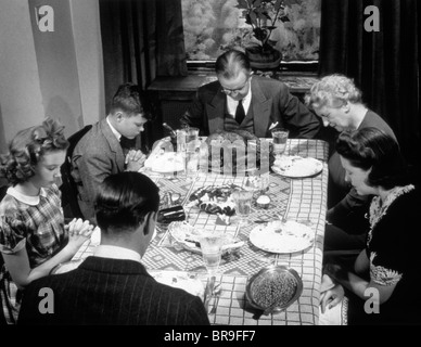 1940 TROIS GÉNÉRATION FAMILLE DISANT GRACE dîner de Thanksgiving Banque D'Images