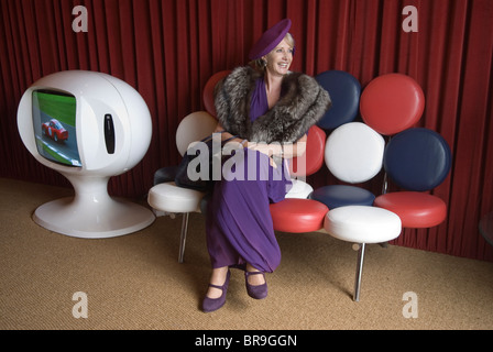 Femme rétro habillée dans le style à la mode des années 1950 1940 au Goodwood Festival of Speed. Goodwood Sussex Royaume-Uni. Salon VIP, chaise vintage et TV. HOMER SYKES des années 2010 2010 Banque D'Images