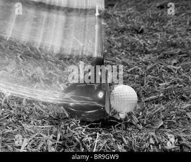 1960 Déménagement du CLUB DE GOLF DRIVER HITTING BALL SUR TEE IN GRASS Banque D'Images