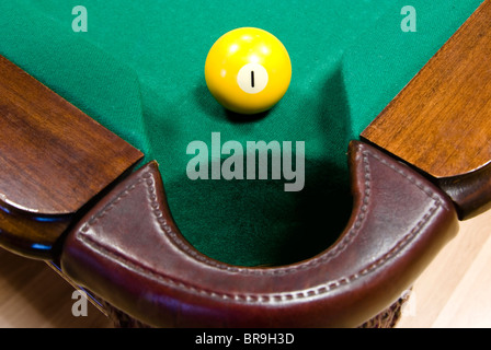 Boule de billard jaune avec le numéro "un" en face de corner pocket sur feutrine verte tableau Banque D'Images