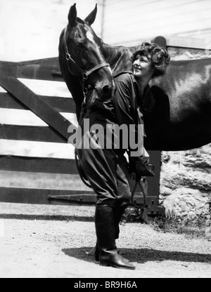 Années 1900 Années 1910 JEUNE FEMME AVEC UPSWEPT DE LEVAGE DE CHEVEUX la patte avant du sabot de nettoyage Contrôle de cheval Banque D'Images