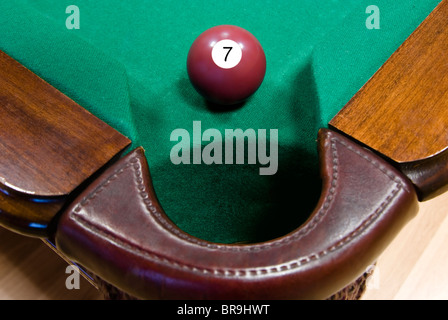 Boule de billard rouge cerise avec le numéro "un" en face de corner pocket Banque D'Images