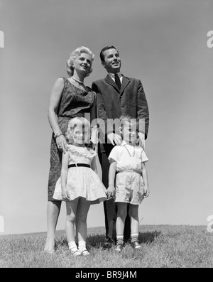 Années 1950 Années 1960 PORTRAIT DEBOUT DANS L'HERBE DE LA FAMILLE Père Mère Fils Fille Banque D'Images