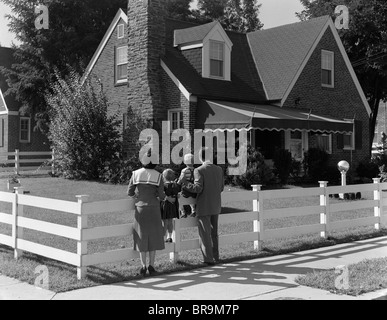 1950 FAMILY clôture blanche à la maison de brique à Banque D'Images