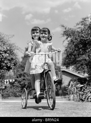 1940 JUMELLES ÉQUITATION EXTÉRIEUR SUR TRICYCLE Banque D'Images