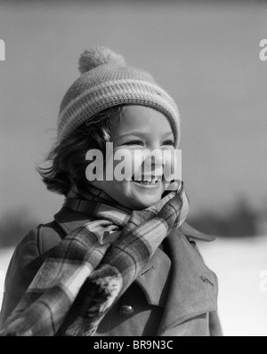 1930 SMILING LITTLE GIRL WEARING HAT VÊTEMENTS D'HIVER ROBE FOULARD Banque D'Images