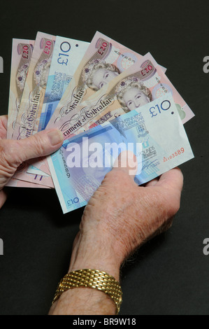 Man holding Gouvernement de Gibraltar numéro publié dix et vingt pound note Banque D'Images