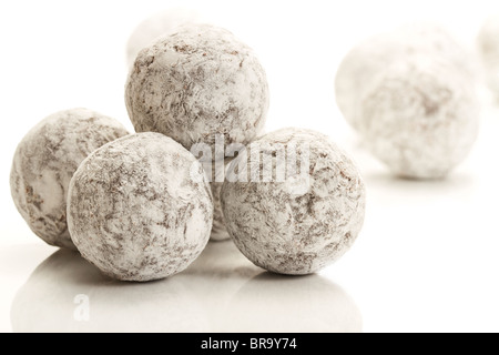 Un peu de sucre en poudre pralines truffe couverte sur fond blanc Banque D'Images