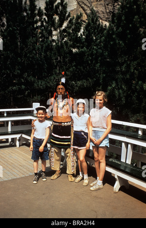 1950 GARÇON ET DEUX PETITES FILLES POSANT AVEC UN INDIEN DE L'AMÉRIQUE DANS LE DAKOTA DU SUD 1956 Banque D'Images