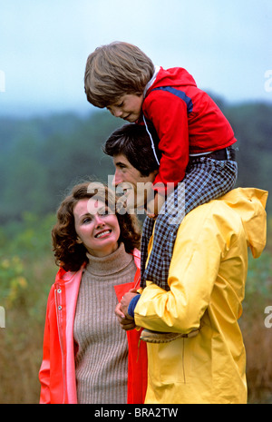 1970 1970 RETRO PARENTS mère père tenant son ON SHOULDERS SMILING FAMILY OUTDOORS Banque D'Images