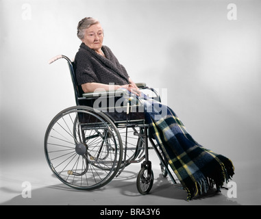 1960 1960 PERSONNES ÂGÉES SENIOR RETRO WOMAN SITTING IN WHEELCHAIR COUVERTURE PLAID CHÂLE SOLITAIRE TRISTE santé Vieillissement Banque D'Images