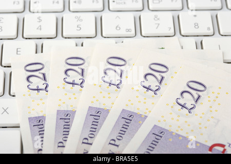 Pile de billets de vingt livres sterling sur un clavier d'ordinateur Banque D'Images