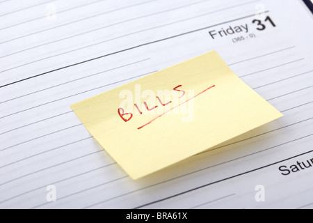 post-it concernant les factures dues collées dans un agenda à la fin du mois de crise du coût de la vie Banque D'Images