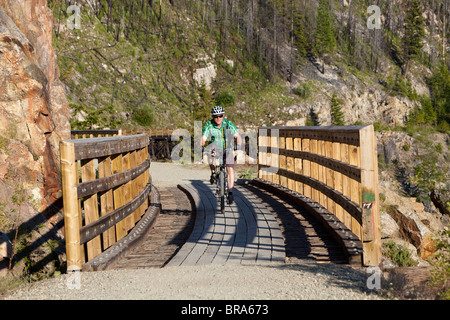 Des promenades en bicyclette à travers trestle à canyon Myra sur la piste cyclable du chemin de fer de Kettle Valley près de Kelowna, Colombie-Britannique, Canada Banque D'Images