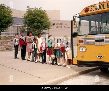 1960 GROUPE D'ENFANTS DANS LES AUTOBUS SCOLAIRES EN LIGNE Banque D'Images