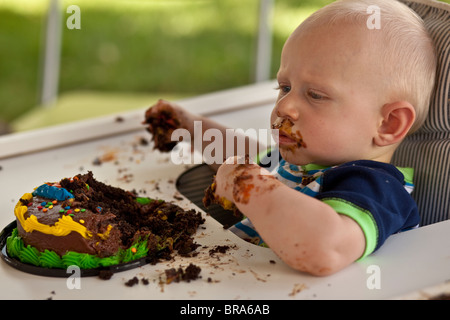 Baby Boy eating premier gâteau d'anniversaire Banque D'Images