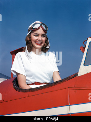Années 1940 Années 1950 SMILING WOMAN WEARING HELMET PILOTES LUNETTES AIRPLANE COCKPIT OUVERT Banque D'Images