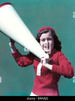 Années 1940 Années 1950 SMILING WOMAN WEARING CHEERLEADER LETTRE VARSITY SWEATER POINTING Banque D'Images