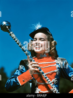 Années 1940 Années 1950 SMILING TEEN GIRL MAJORETTE TAMBOUR-MAJOR EN UNIFORME TENANT UN BATON PERSONNEL Banque D'Images