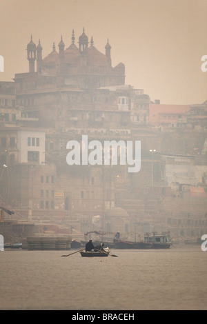 Un bateau, c'est ramé sur un matin brumeux dans le Ganga (le Gange) Rivière à Varanasi, Uttar Pradesh, Inde, Asie Banque D'Images