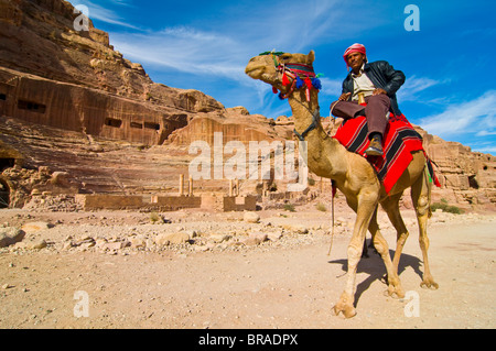 Sur un chameau bédouin en face de l'amphithéâtre de Pétra, Site du patrimoine mondial de l'UNESCO, la Jordanie, Moyen-Orient Banque D'Images