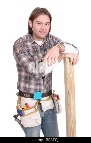 Un jeune homme de la vingtaine de travail les outils de construction de travail sur fond blanc Banque D'Images