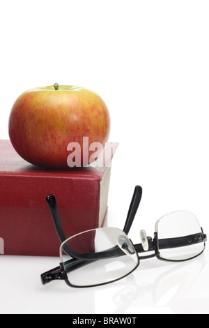 Apple, lunettes de lecture et livre sur fond blanc avec copie espace Banque D'Images