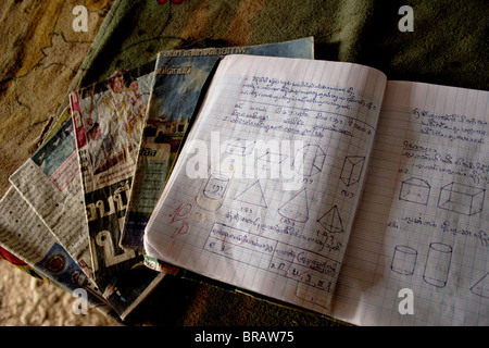 Un cahier de l'élève afficher un score de mathématiques parfait repose sur une table dans sa maison à Ban Buamlao, Laos. Banque D'Images