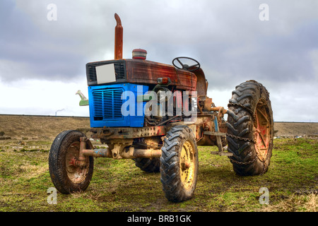 Image d'un tracteur sur une vintage abandonnés grass field Banque D'Images