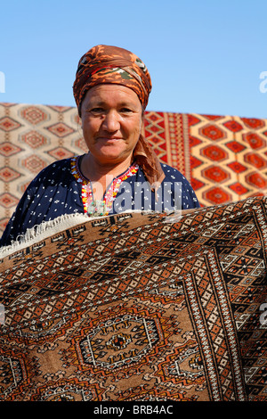 - Turkménistan Ashgabat - femme affiche un tapis au marché du dimanche Banque D'Images