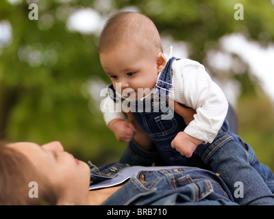 Mère jouant avec un sourire heureux bébé de quatre mois garçon dans la nature Banque D'Images