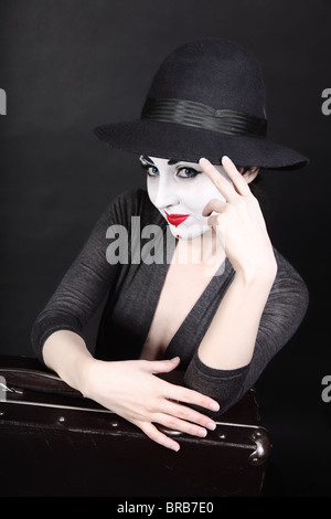 Femme artiste mime avec le maquillage de théâtre et de hat with suitcase Banque D'Images