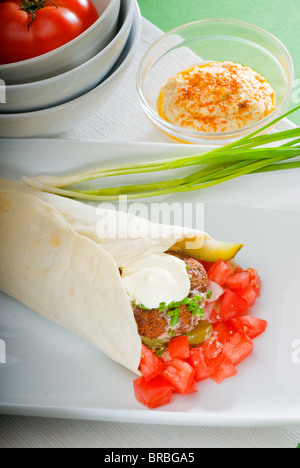 Falafel traditionnelle frais emballage sur le pain pita avec des tomates fraîches hachées Banque D'Images