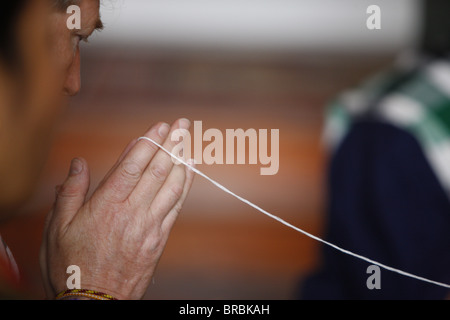 Cérémonie bouddhiste lao avec bracelets de coton, Paris, France Banque D'Images