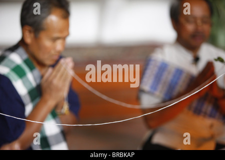 Cérémonie bouddhiste lao avec bracelets de coton, Paris, France Banque D'Images