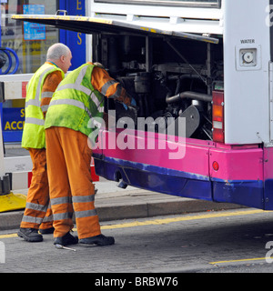 L'examen de mécanique de compartiment moteur bus en panne Banque D'Images