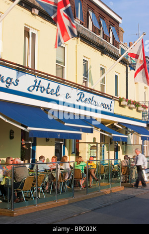 Les touristes assis à l'extérieur des restaurants et bars, Gorey harbour, Jersey, Channel Islands, Royaume-Uni Banque D'Images