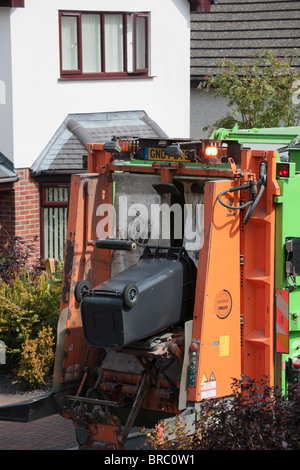 Ben les hommes de vider les ordures ménagères de wheelie bins en camion dans la rue. Anglesey au nord du Pays de Galles, Royaume-Uni, Angleterre. Banque D'Images