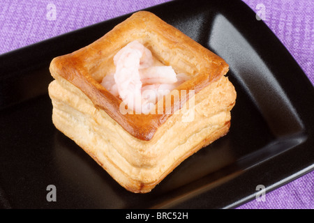 Close-up of a squared vol-au-vent farci de petites crevettes cuites sur une plaque noire Banque D'Images