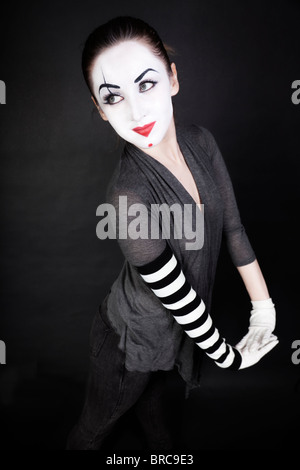 Happy woman mime sur un fond noir Banque D'Images