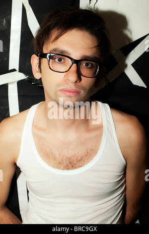 Portrait d'une jeune brunette guy dans l'élégant quartier de verres et un T-shirt blanc Banque D'Images