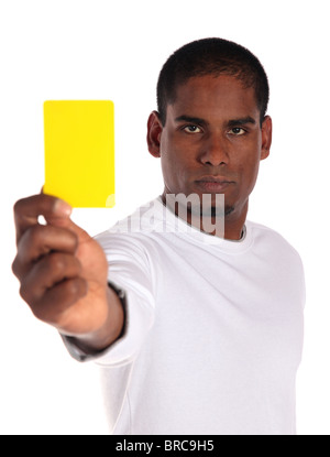 Un bel homme à la peau sombre montrant une carte jaune. Le tout sur fond blanc. Banque D'Images