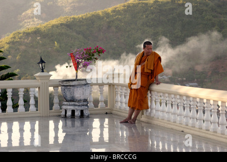 Un moine bouddhiste semble être dans la pensée comme il se tient sur le pont de marbre marbre d'un temple à Mae Sae (SAI) de la Thaïlande. Banque D'Images