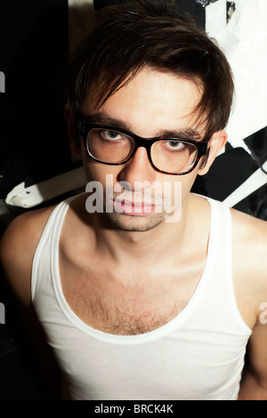 Portrait d'une jeune brunette guy dans l'élégant quartier de verres et un T-shirt blanc Banque D'Images