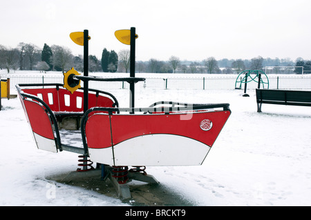 Une aire de jeux pour enfants dans un parc couvert de neige Banque D'Images